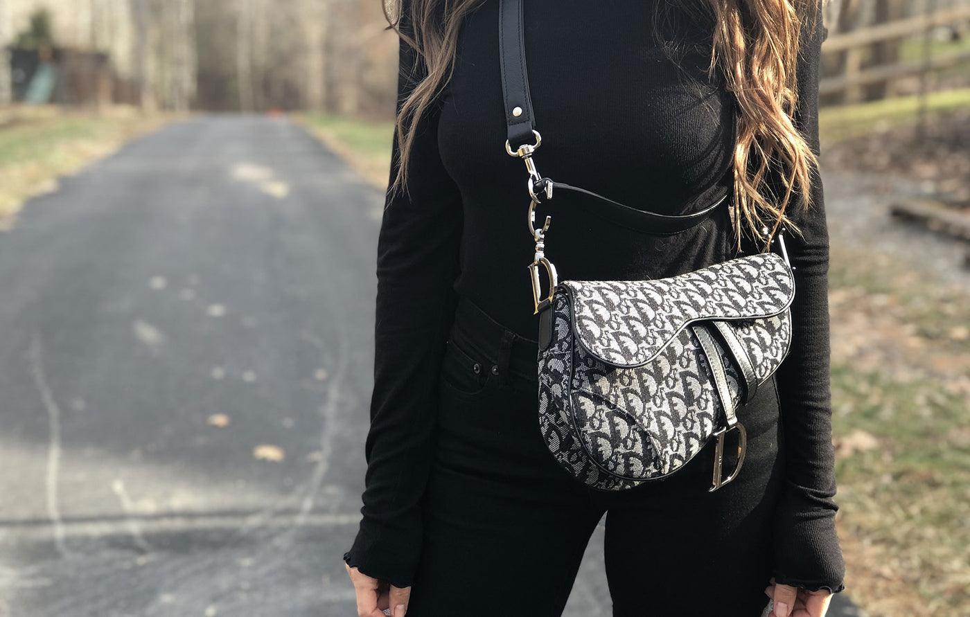 Photo of leather cross body strap on a woman's designer handbag.