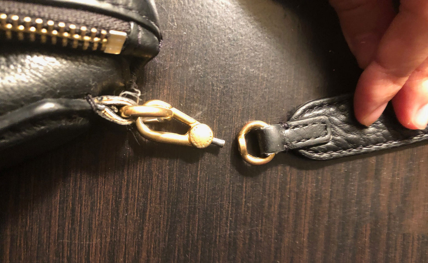 Photo of a broken leather strap, needing repair.