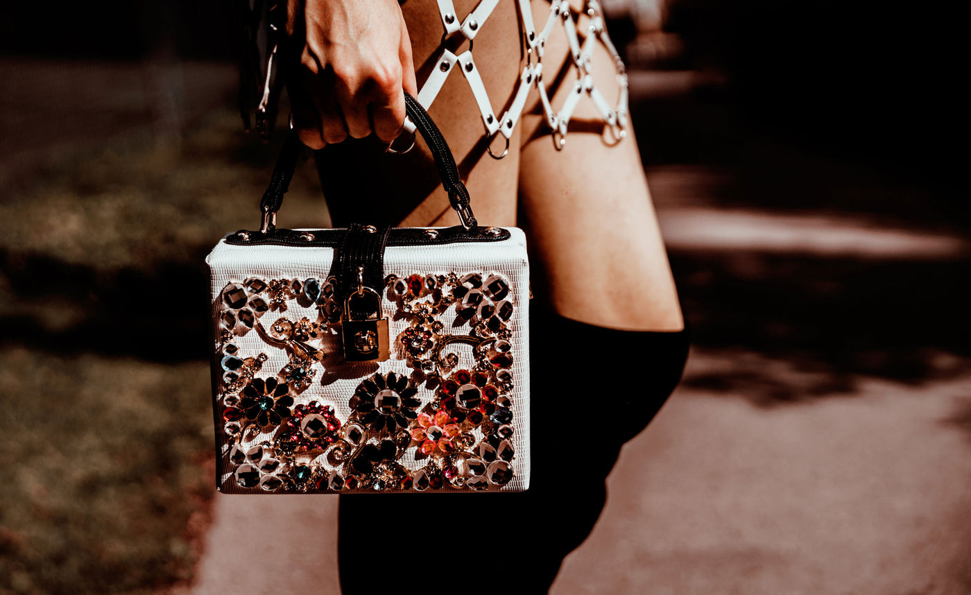 Stylish handbag held by fashionable person.